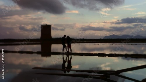 A couple posing amidst the salt falts of trappani, Sicily, Italy photo