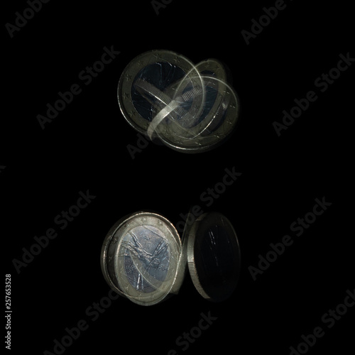 Spinning coin in stroboscopic light. Italian one euro, close up photo