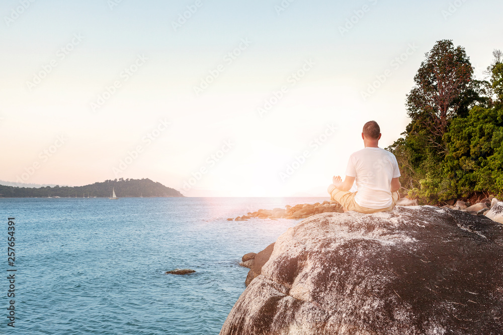 Young Man Meditating on beach.