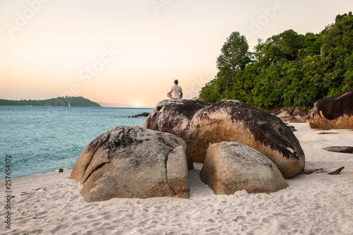 Man Meditating and doing Yoga Exercises on beach photo