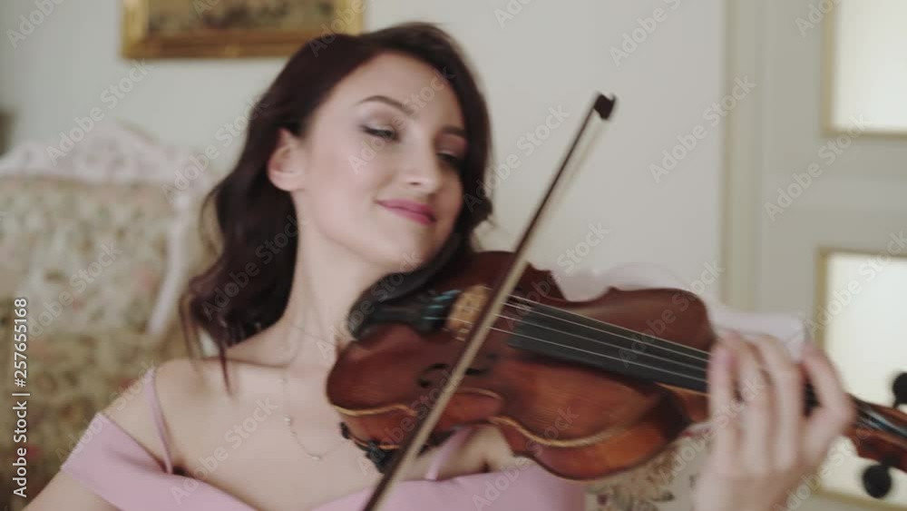 Smart female violinist playing at camera with smile on face. 4K Smart female violinist playing at camera with smile on face. 4K