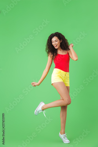 Full length portrait of fitness girl 20s dressed in summer clothes smiling and walking