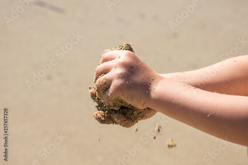 Child's hands playing with sand