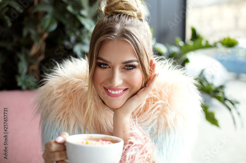 Happy girl drinking coffee in cafe. photo