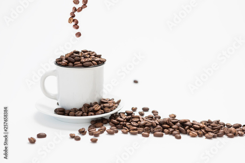 White Coffee Cup With Fresh Coffee Beans Falling into the Cup on a White Background Concept with Copy Space