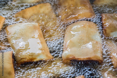 Imqaret - diamond date filled pastries -  frying in hot oil