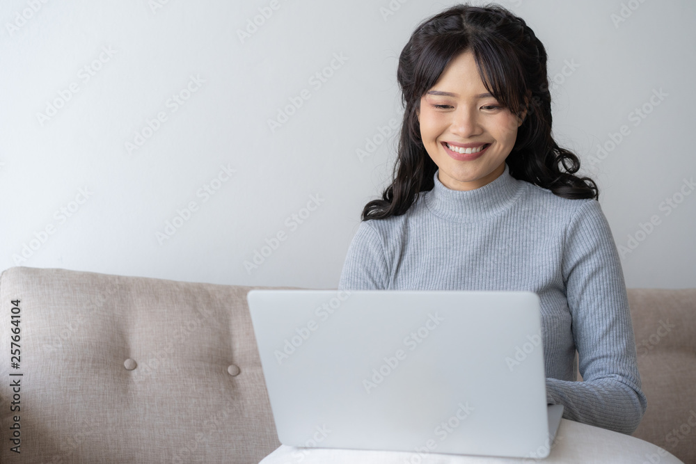 Asian women using laptop at home,Asian girl sitting and smiling working at home Asian women using laptop at home,Asian girl sitting and smiling working at home