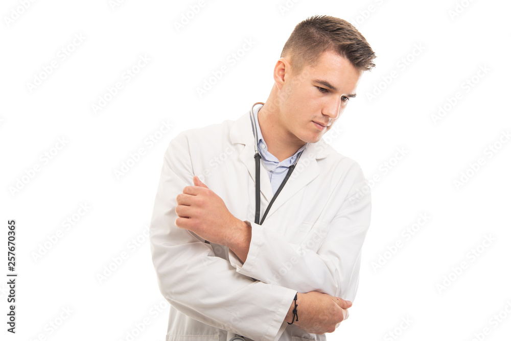 Portrait of young handsome doctor holding elbow like hurting Portrait of young handsome doctor holding elbow like hurting