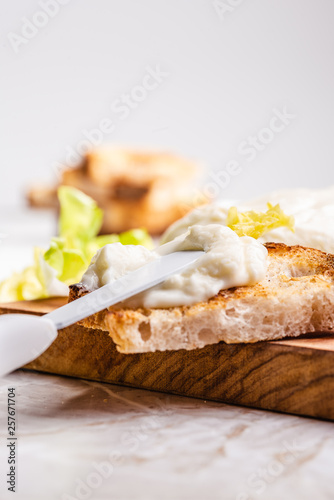 Italian spreadable cheese called stracchino served with slices of toasted bread 