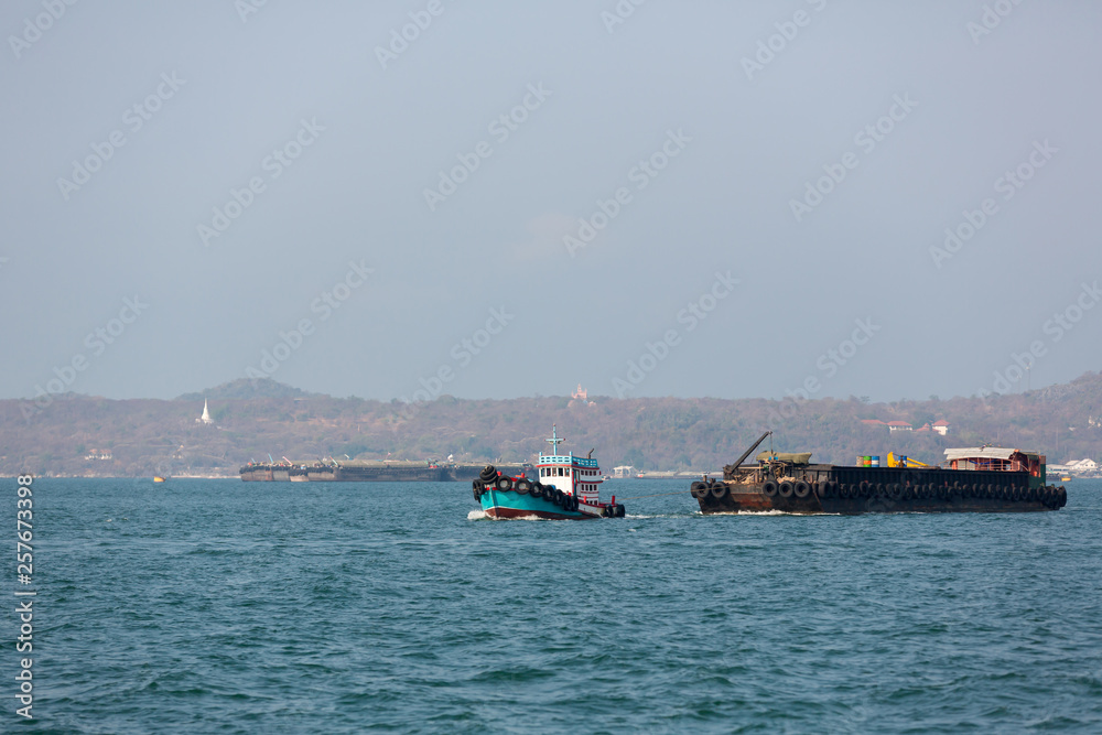 Small towing tugboat dragging the huge Dredger ship in the sea. Drilling industry in the ocean. image for background, wallpaper, advertisement,objects and copy space. Small towing tugboat dragging the huge Dredger ship in the sea. Drilling industry in the ocean. image for background, wallpaper, advertisement,objects and copy space.