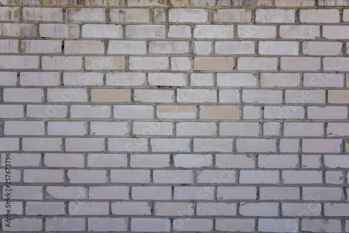 old white yellow brick wall with cracks and scratches. rough surface texture