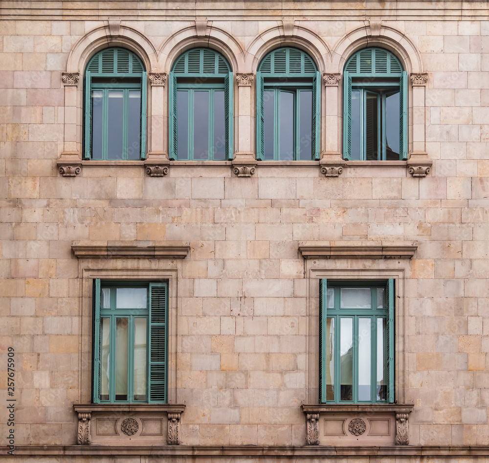 Several windows in a row on the facade of the urban historic building front view, Barcelona, Spain