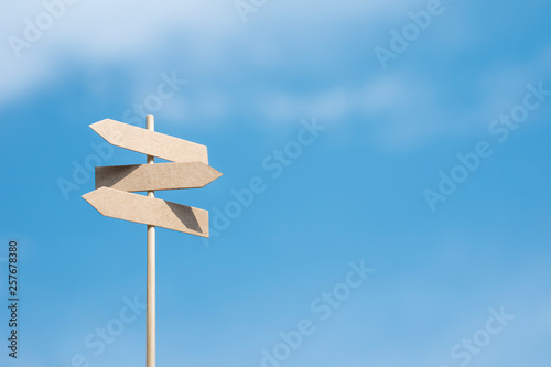 Empty three arrows road signpost template on a blue sky background