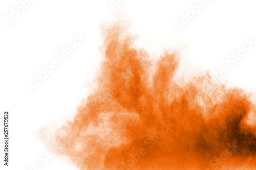 Abstract explosion of orange dust on white background. Freeze motion of orange powder splashing.