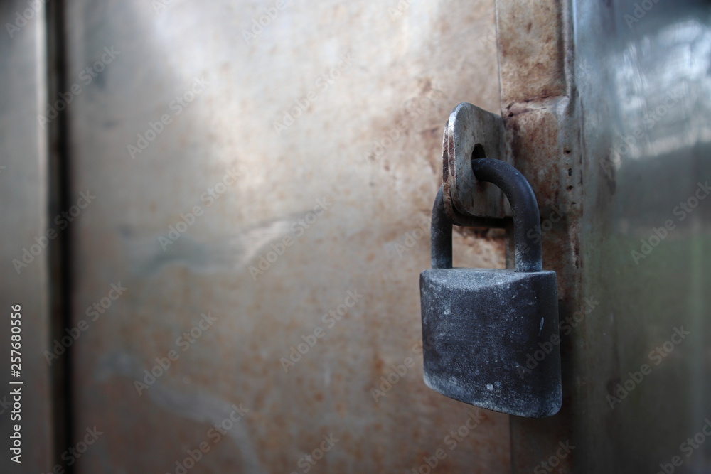 Safety black padlock locked the dirty stainless doors. Safety black padlock locked the dirty stainless doors.