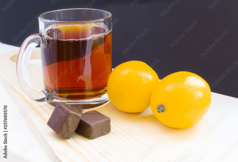 cup of tea with lemon and with chocolate on dark background cup of tea with lemon and with chocolate on dark background
