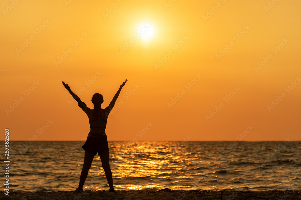 Exercise spirit lifestyle mind woman peace vitality, silhouette outdoors on the Sea sunrise, relax and freedom vital abstract. Healthy and Sport Concept
