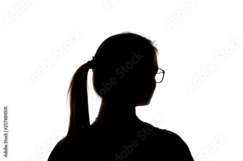 Silhouette of girl in glasses with ponytail looking away isolated on white