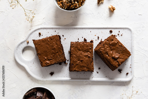Chocolate brownie cake, dessert with nuts on dark background, directly above, copy space