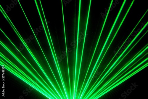 Green laser show nightlife club stage and shining sparkling rays. Luxury entertainment in nightclub event, festival, concert or New Years Eve. Ray beams are symbol for science and universe research
