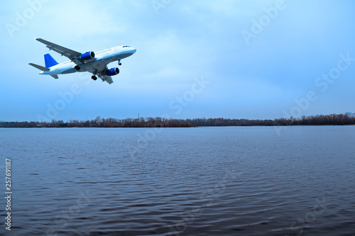 The plane over the river in the evening in nature.