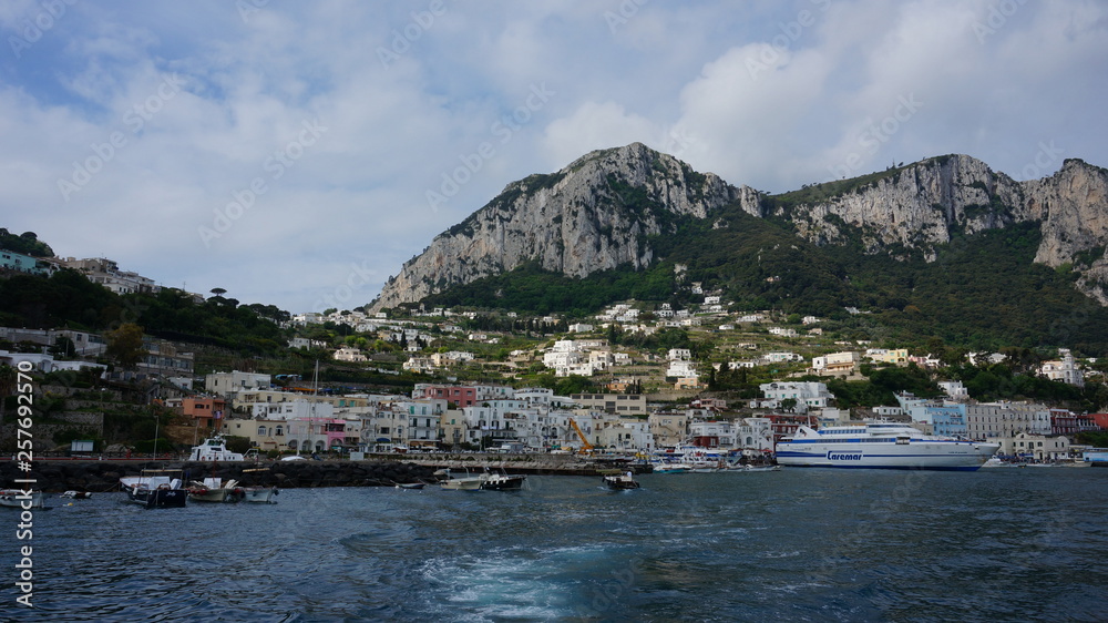 A panorama across the breakwater of the harbour of Marina Grande with Mount Solaro and Anacapri in the distance on the island of Capri, Italy