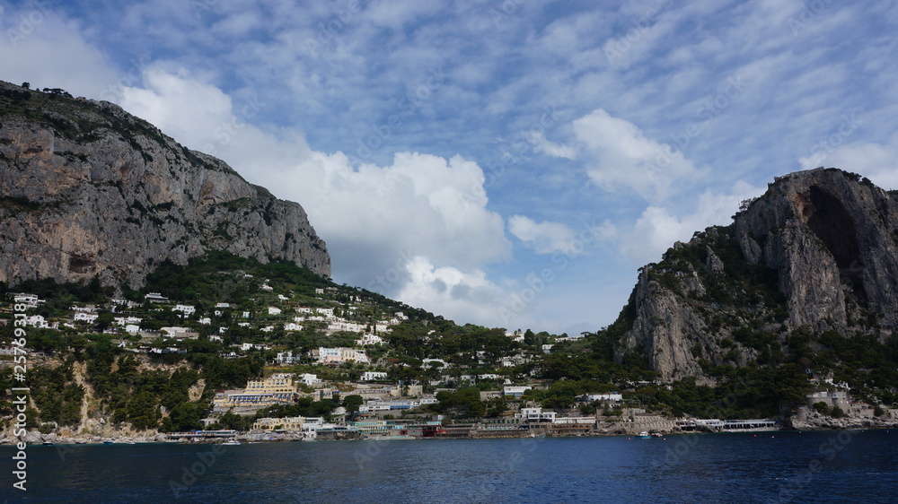 A panorama across the breakwater of the harbour of Marina Grande with Mount Solaro and Anacapri in the distance on the island of Capri, Italy