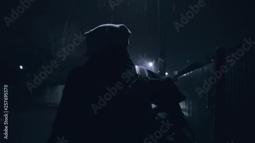 Back view on silhouette of a man in the hood. The criminal is hiding from the police photo