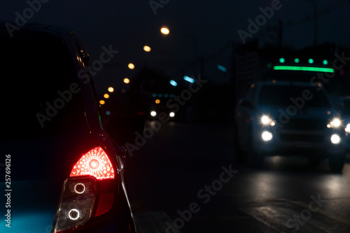 Focus the rear brake lights of the car on the night road in Thailand.