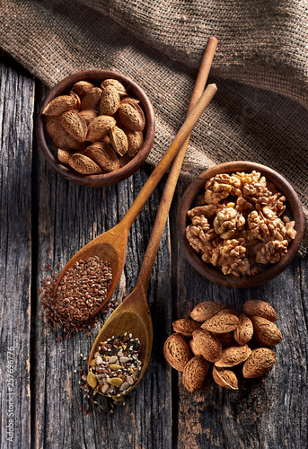 Food ingredients in wooden spoon on wooden background. Flax, pumpkin seed, sunflower and sesame.