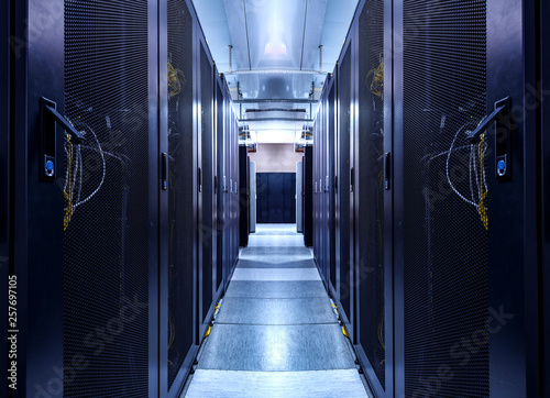 Shot of Corridor in Working Data Center Full of Rack Servers and Supercomputers. concept of big data storage and cloud computing technology.