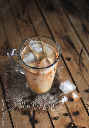 Ice coffee in a glass on wooden background 