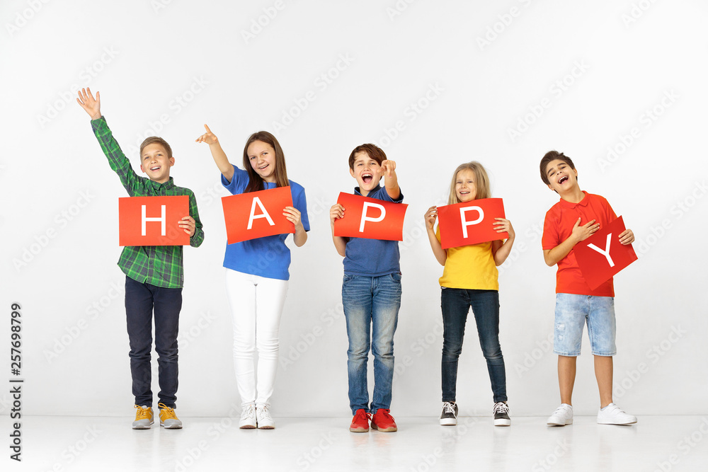 Friendship make us better. Group of happy smiling children with red banners making word isolated in white studio background. Education and advertising concept. Friendship make us better. Group of happy smiling children with red banners making word isolated in white studio background. Education and advertising concept.