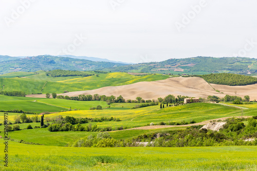 Italian farm on a hill with fields in a rural landscape