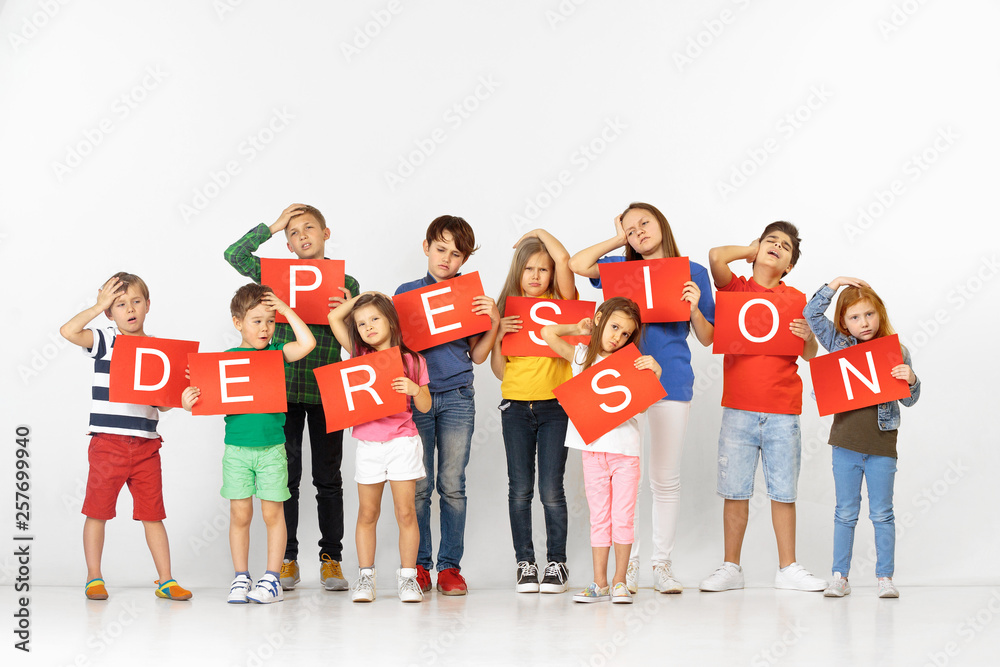 Obraz premium Depression kills your character. Group of saddened and distressed children with red banners isolated on white studio background. Education and advertising concept. Protest, children's rights concepts.