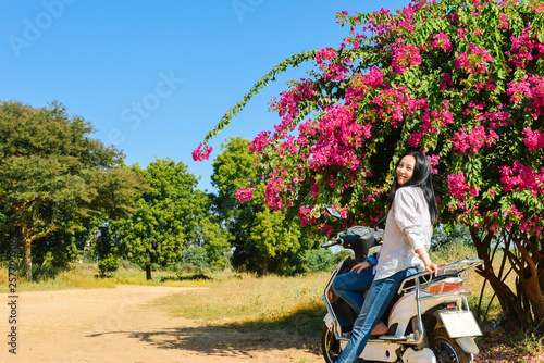 girl leans on motorbike looking at camera at Bagan, Myanmar photo