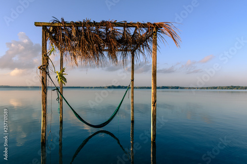 wooden construction with a hammock in a lake called Laguna Milagros at sunset, Chetumal, Mexico