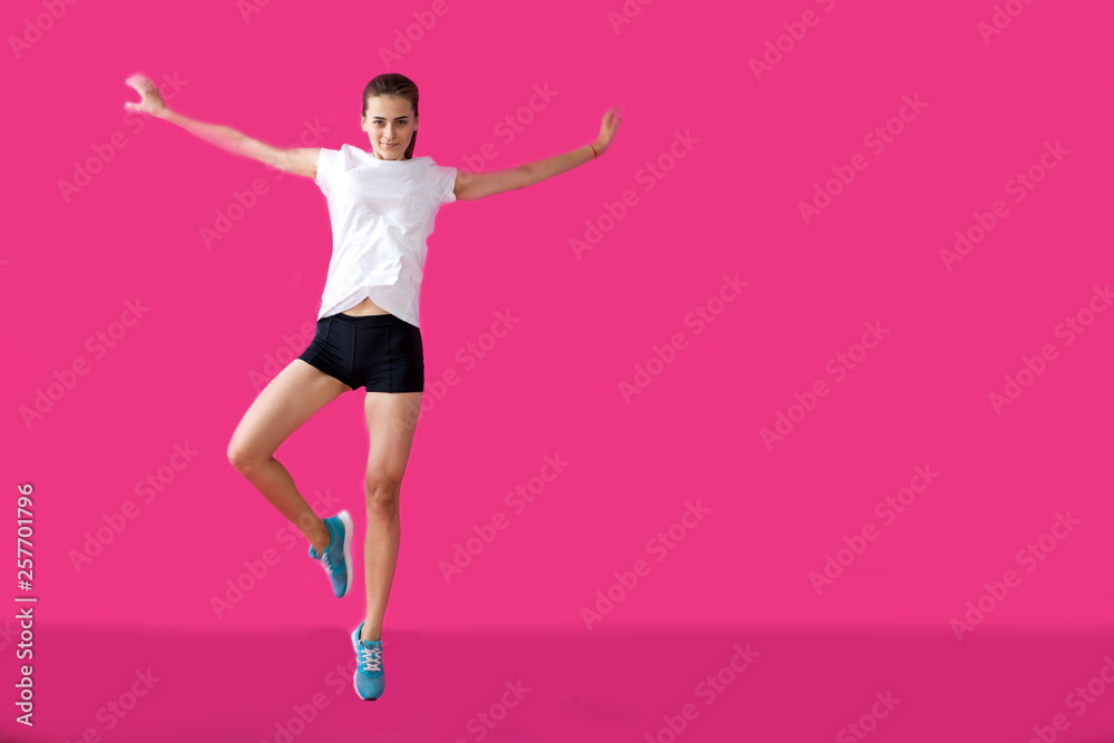girl sportsman posing on a pink background girl sportsman posing on a pink background