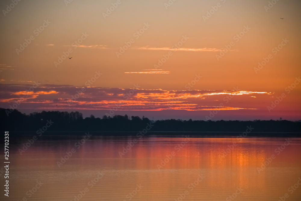 Bright pink and orange sky at dawn on a lake in Florida