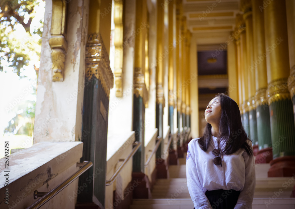 girl looking out window at the entrance of the famous Shwedagon Pagoda, Yangon