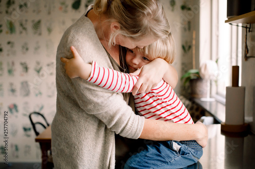 Mother embracing daughter in kitchen