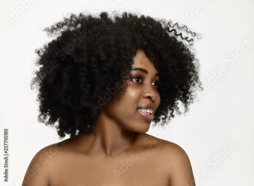 Portrait of young black african american smiling and surprised woman with braces on white studio background