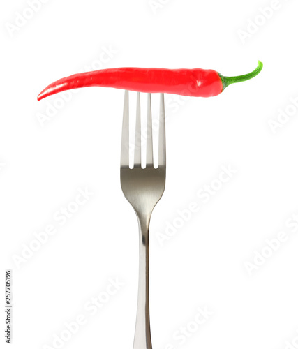 Hot red chili pepper one single whole on impaled on a fork isolated on white background with clipping path. © elenvd