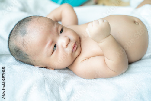 Adoraable infant baby boy lying on white blanket