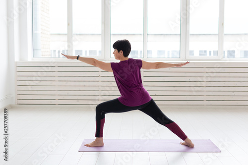 Yoga, people concept - a middle-aged woman doing a yoga and try to do a asana