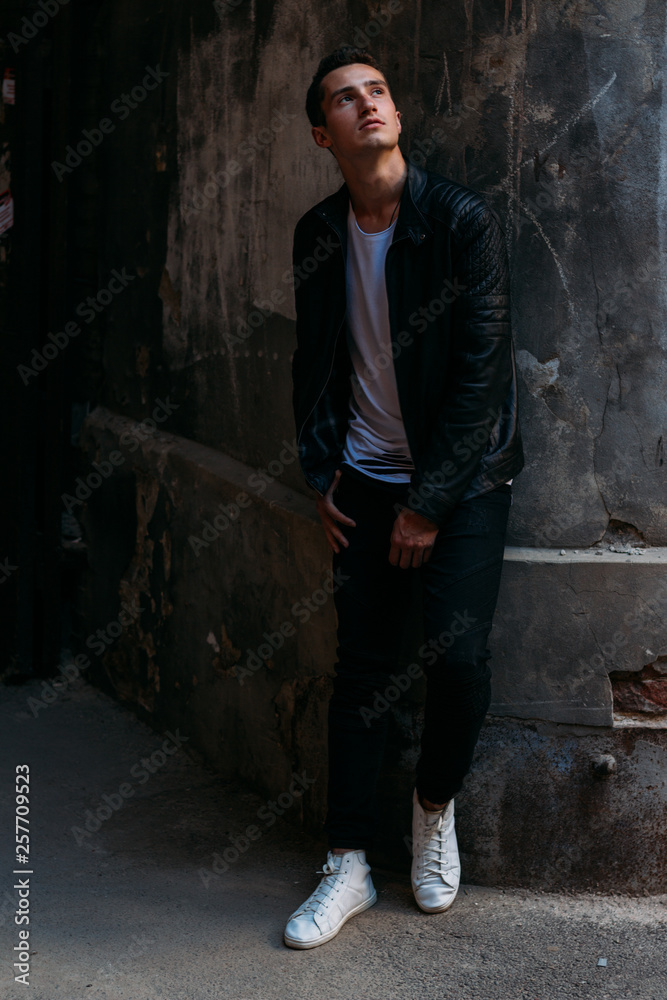 Attractive, sexy guy standing on the street in sunglasses. self-confidence, flatulence and arrogance. model, posing, portrait of a young man