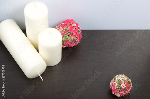 Candles white in color among the decorative balls  woven from natural materials.
