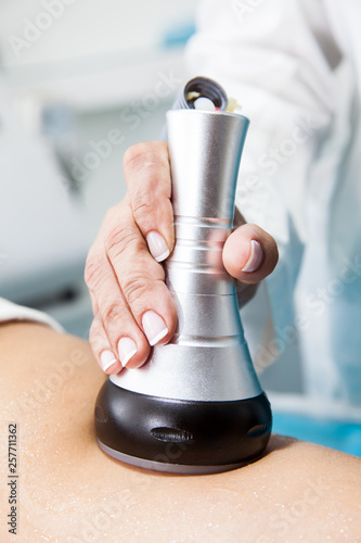 Bilde på lerret Doctor performing an  ultracavitation treatment on a young female patient leg