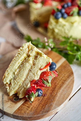 Serving of a ppistachio layer cake with berries photo