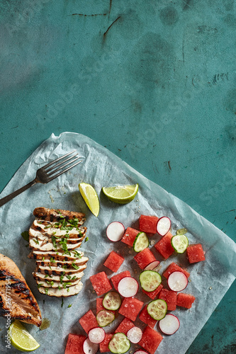 Grilled chicken with fresh watermelon, cucamber and radich salad photo